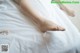 A woman's bare feet on a bed with white sheets.