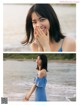 A woman in a blue dress standing on a beach.