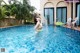 A woman in a bikini standing in a swimming pool.