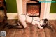 A woman in lingerie and stockings laying on the floor in front of a fireplace.