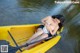 A woman sitting in a yellow kayak on the water.