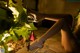 A woman in high heels sitting on the ground next to a plant.