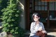 A woman sitting on the ground in front of a building.