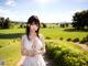 A woman in a white dress standing in a field.